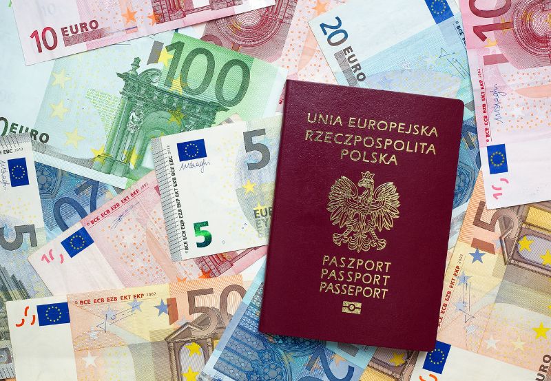 Polski paszport na tle banknotów euro