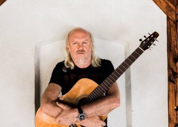 Na zdjęciu znajduje się Andrzej Sikorowski, który trzyma w rękach gitarę