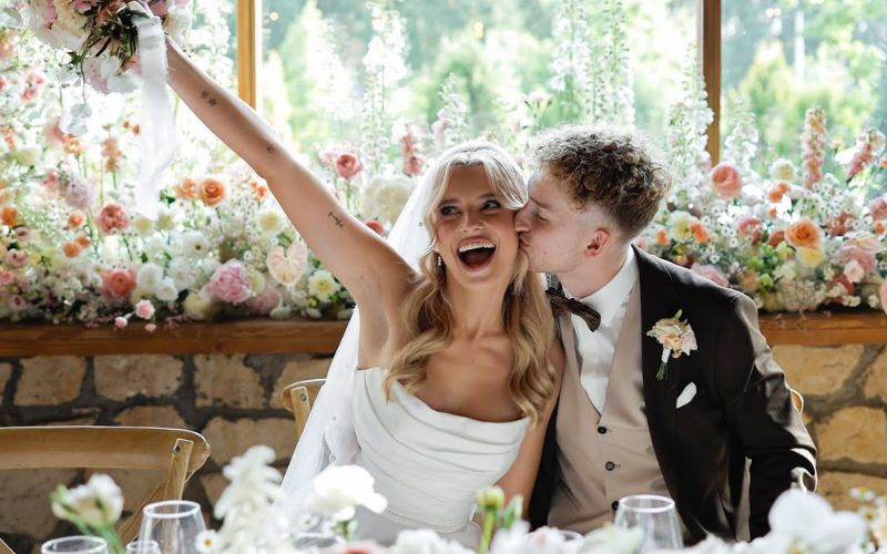 Na zdjęciu znajduje się Kaluch ze swoją żoną Wiktorią w dzień ich ślubu, którzy siedzą przy stole weselnym