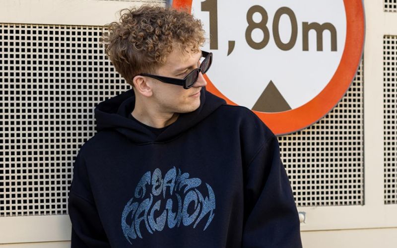 Na zdjęciu znajduje się Kaluch, który pozuje w bluzie Teamkaluch