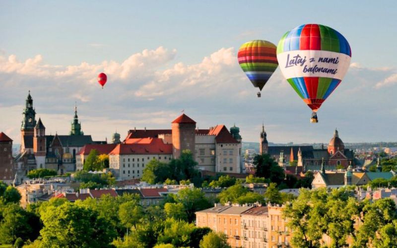 Zdjęcie przedstawia 3 balony unoszące się nad panoramą Krakowa