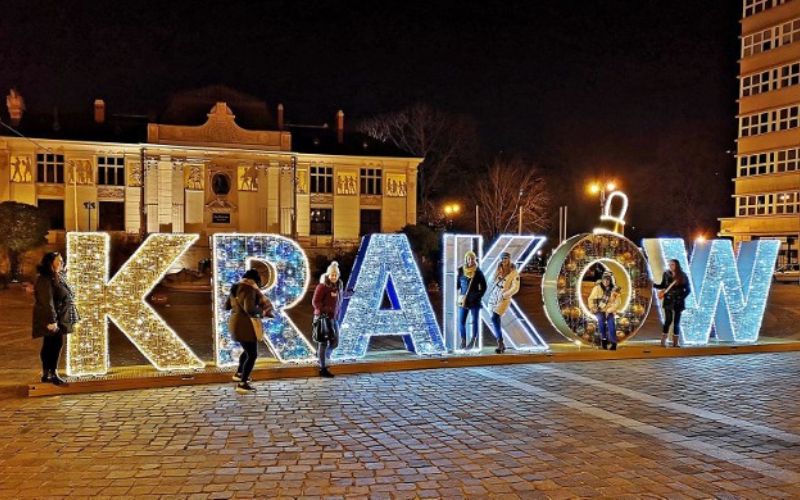Zdjęcie przedstawia świąteczną iluminację - napis "Kraków" podświetlony