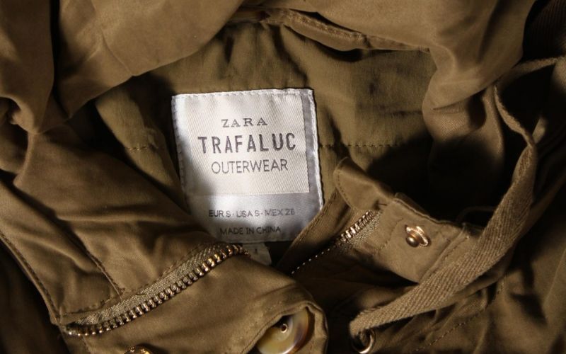 Zdjęcie przedstawia metkę z zary TRF przyczepioną do kurtki