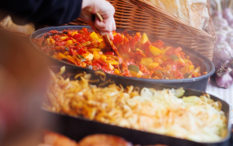 Zdjęcie przedstawia parujące potrawy na jarmarku bożonarodzeniowym