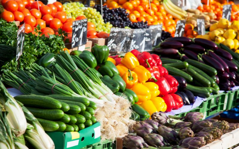 Zdjęcie przedstawia owoce i warzywa na targowisku