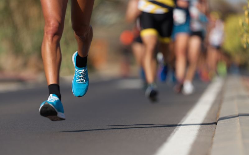 Zdjęcie przedstawia nogi osób biegnących