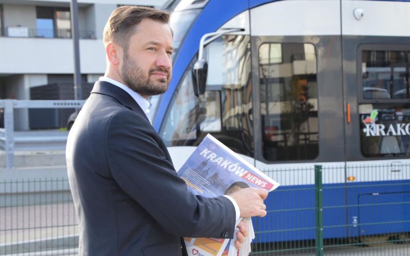 Zdjęcie przedstawia prezydenta Krakowa Aleksandra Miszalskiego, który stoi przy tramwaju