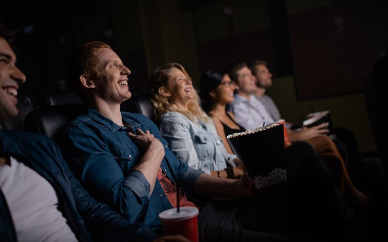 Zdjęcie przedstawia osoby siedzące w kinie