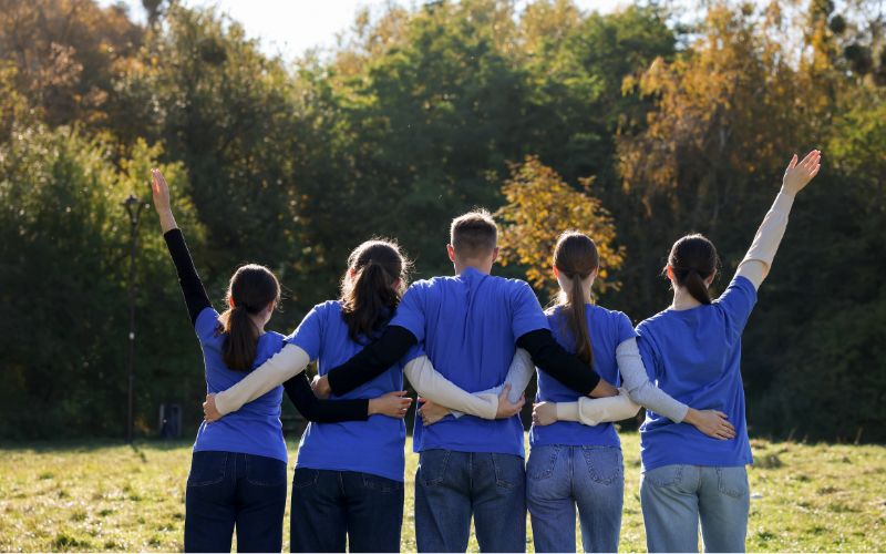 Zdjęcie przedstawia wolontariuszy , którzy się obejmują
