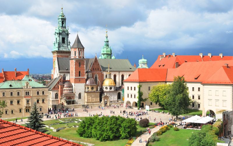 Zdjęcie przedstawia zabytek w Krakowie w otoczeniu zieleni