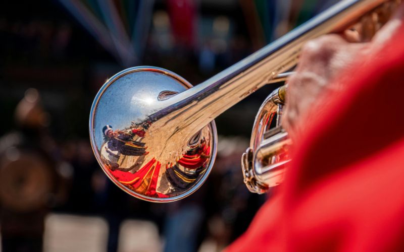 Zdjęcie przedstawia hejnalistę grającego na trąbce