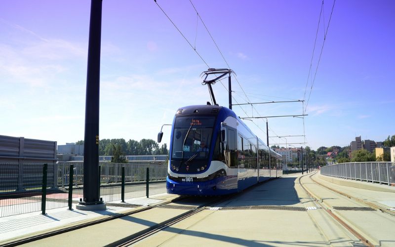 Zdjęcie przedstawia tramwaj Krakowiak na przystanku