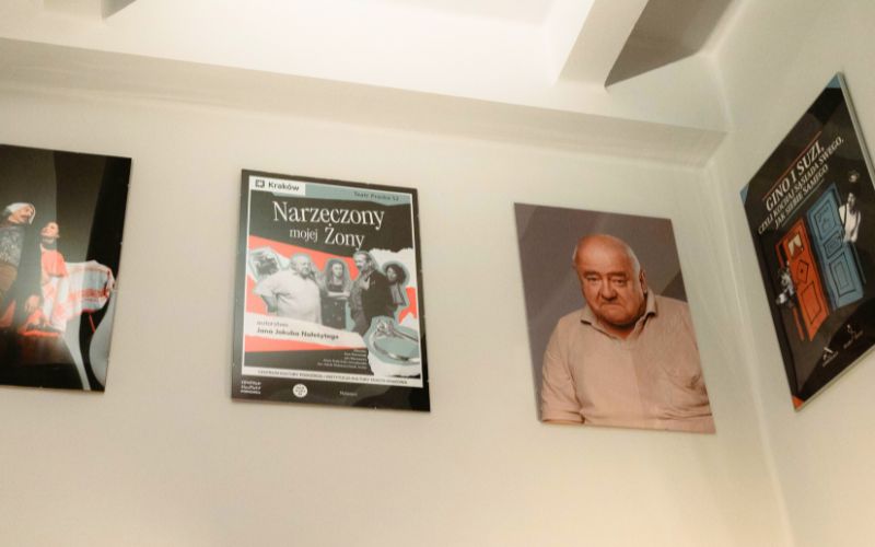 Zdjęcie przedstawia ścianę wypełnioną plakatami związanymi z praskafe