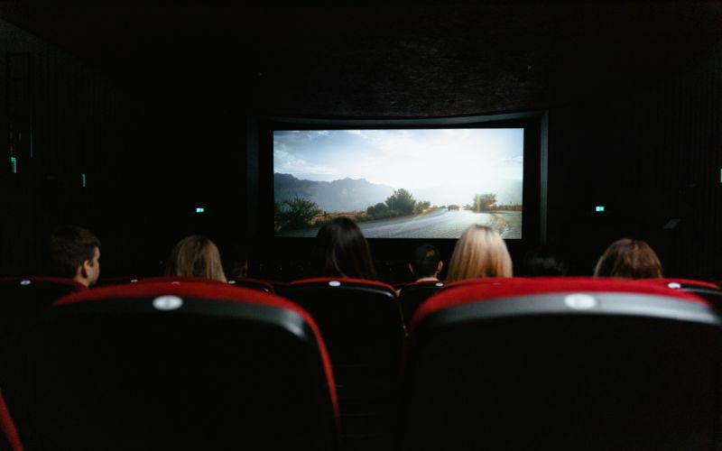 Zdjęcie zrobione zza pleców osób, które oglądają film w kinie