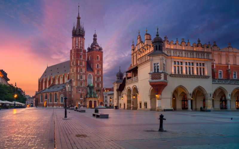 Zdjęcie przedstawia rynek w Krakowie o zachodzie słońca
