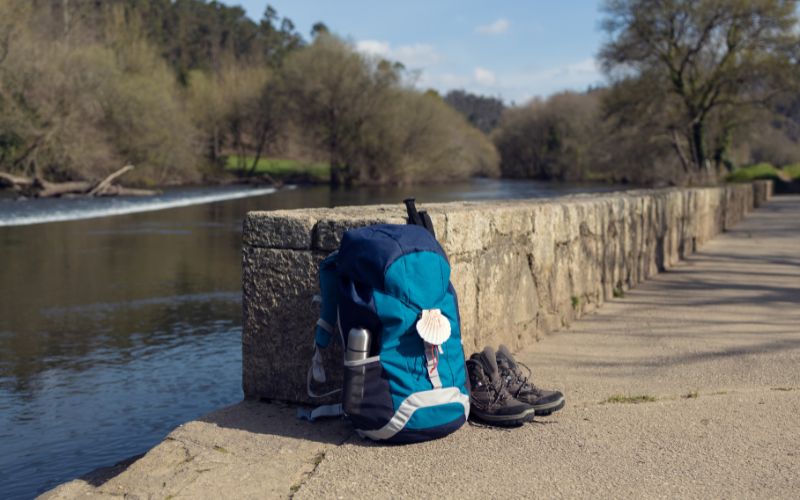 Zdjęcie przedstawia torbę podróżna i buty trekkingowe na dworze