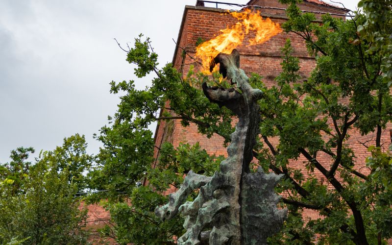 Zdjęcie przedstawia smoka wawelskiego ziejącego ogniem