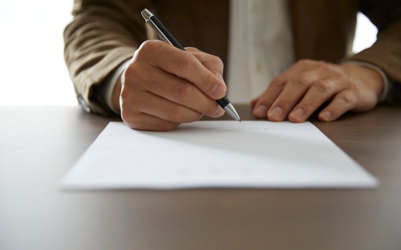 Zdjęcie przedstawia podpisywanie karty podczas wyborów